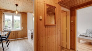 Un intérieur en bois comprenant un coin repas, une cuisine et une chambre à coucher.