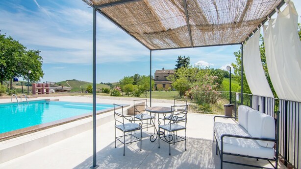 A covered outdoor area with a pool, seating, and a view of the countryside. - Apartment in Ascoli Near Mountains (Ripatransone)