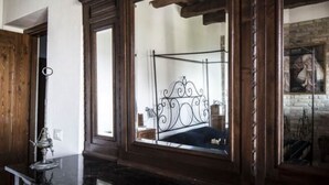 A bedroom with a wooden headboard, a bed with a metal frame, a small table with a lamp, and a painting on the wall. - Lovely Apartment in Ascoli Piceno with Hot Tub (Ripatransone)