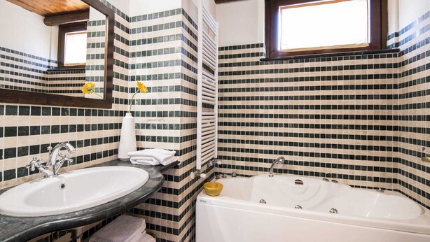 A bathroom with a white sink, a bathtub, and a mirror.