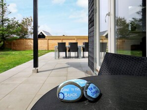 A patio with two stones labeled 'Gone to the Beach' and 'Bin Am Strand' on a table. - Holiday Home in Thisted (Thisted)
