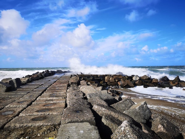A stone pier leading to the sea with waves crashing against it. - Holiday Home in Thisted (Thisted)