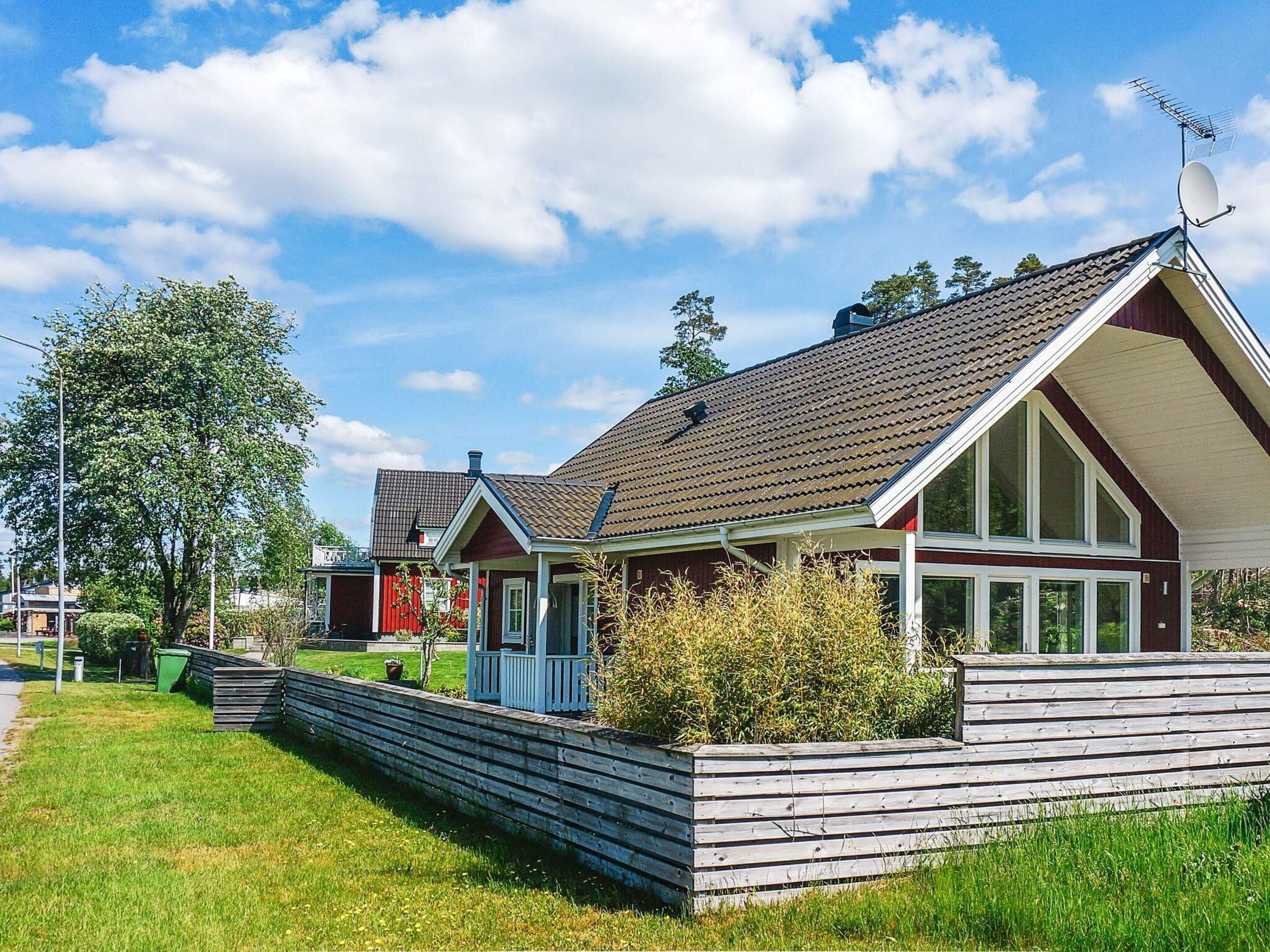 A residential property with a sloped roof, a satellite dish, and a wooden deck.