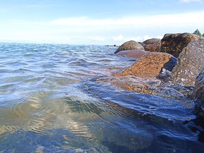 A rocky shoreline with clear water and distant land. - 2 Person Holiday Home in Otterup (Otterup)