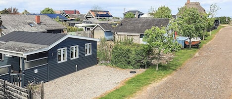 A residential area with houses, a gravel path, and a small boat.