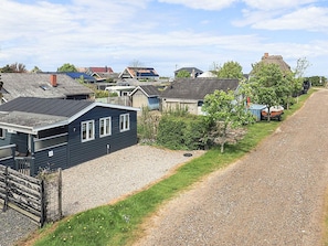 Een woonwijk met huizen, een grindpad en een klein bootje.