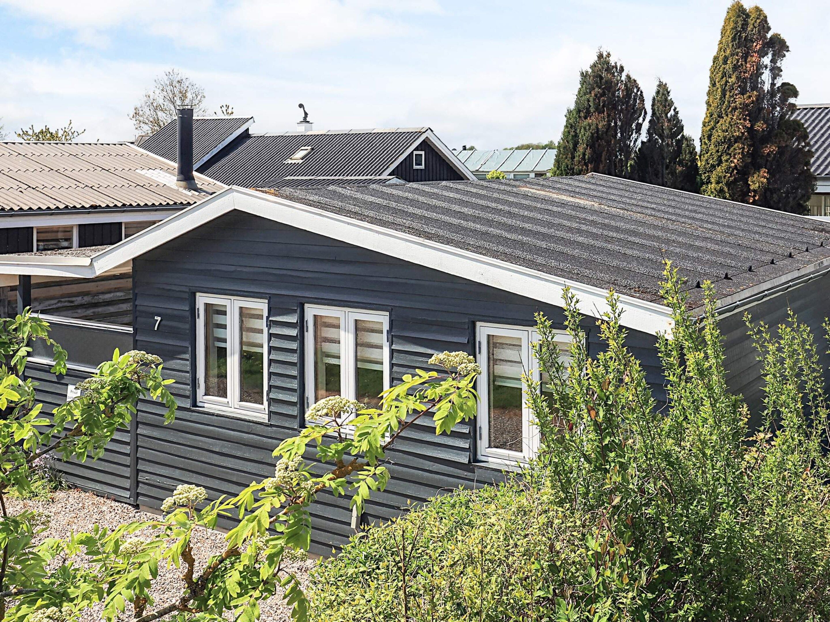 A residential building with a sloped roof, multiple windows, and a chimney.