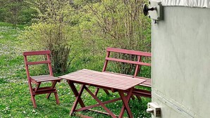 A picnic table and chairs set outdoors with a grassy area and trees in the background. - 4 Person Holiday Home in Lottorp (Löttorp)