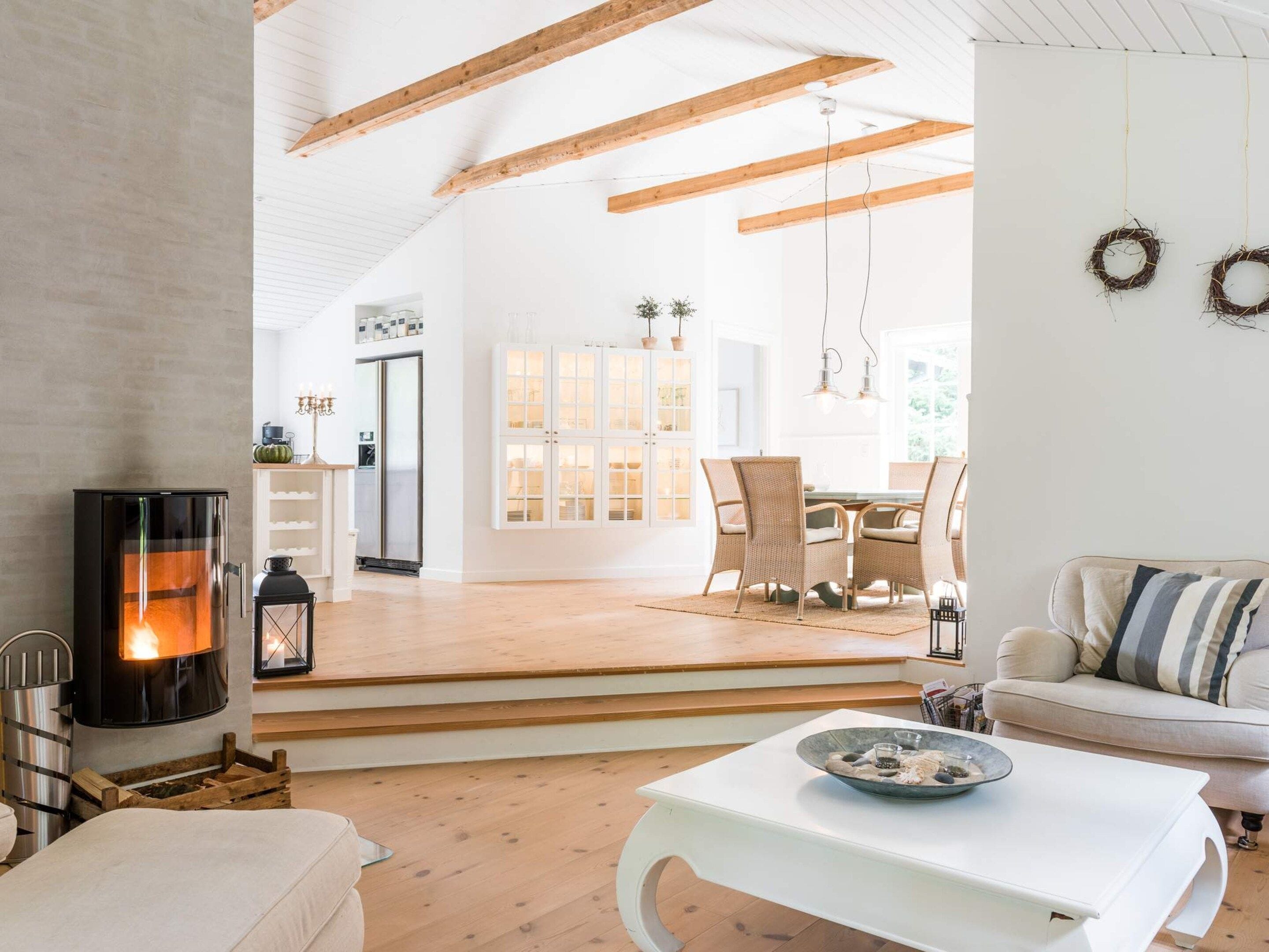 A modern interior with a fireplace, a dining area, and a cozy seating space.