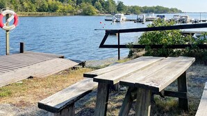 Un espace de pique-nique au bord du lac, équipé de bancs en bois et d’une bouée de sauvetage.