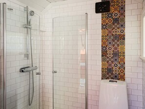 A modern bathroom with a glass-enclosed shower, white tiled walls, and a decorative tile backsplash. - 5 Person Holiday Home in Mellosa (Flen)