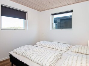 A bedroom with two beds, wooden ceiling, and two windows with blinds. - Holiday Home in Odder (Odder)
