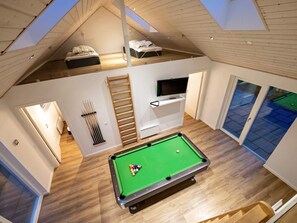 An attic room with a pool table, a TV, and a loft bed. - Holiday Home in Odder (Odder)