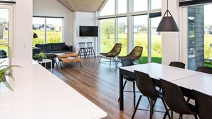 Un interior moderno con comedor, asientos y televisor.