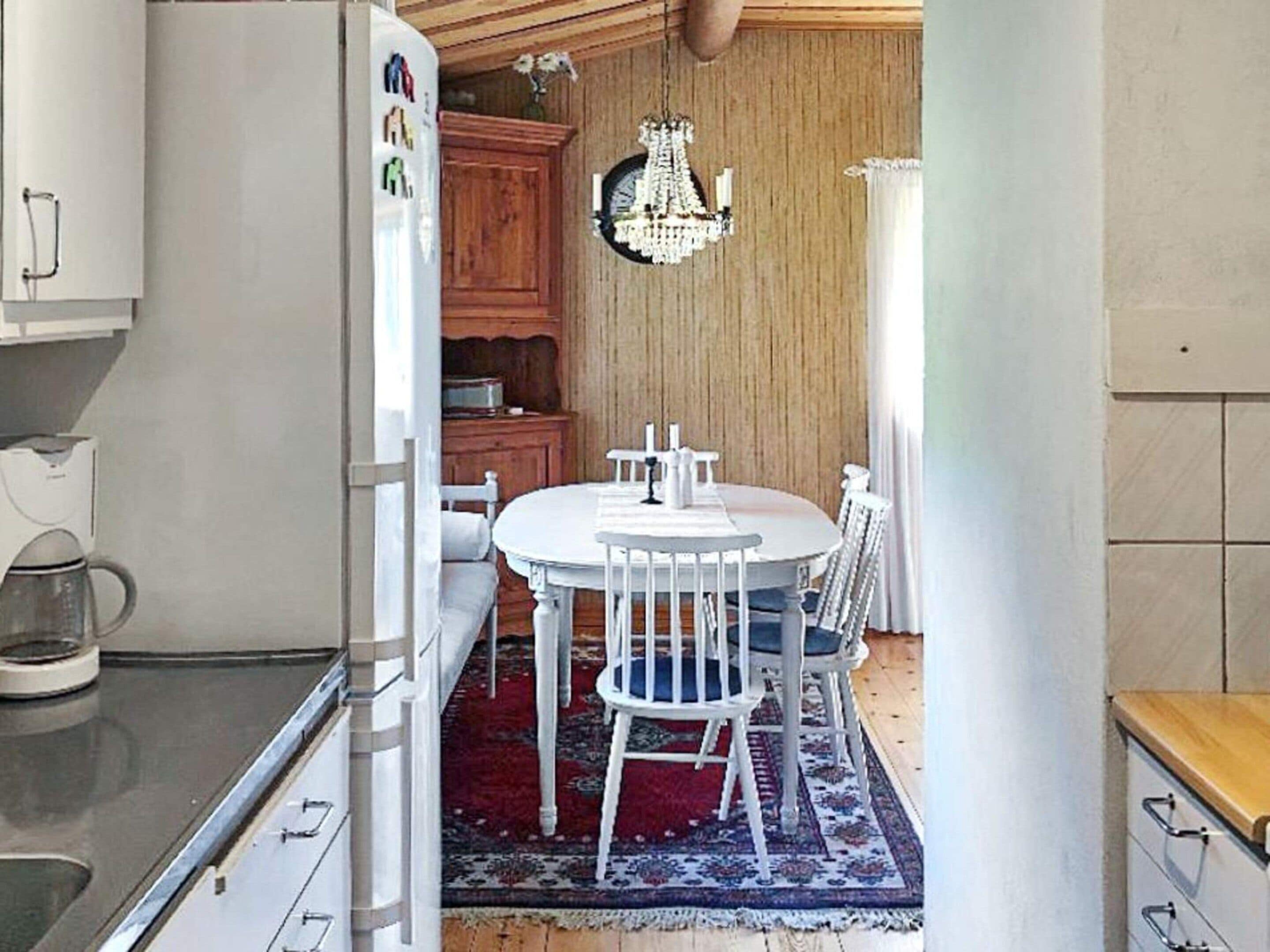 A compact kitchen with a refrigerator, a coffee maker, and wooden cabinets.