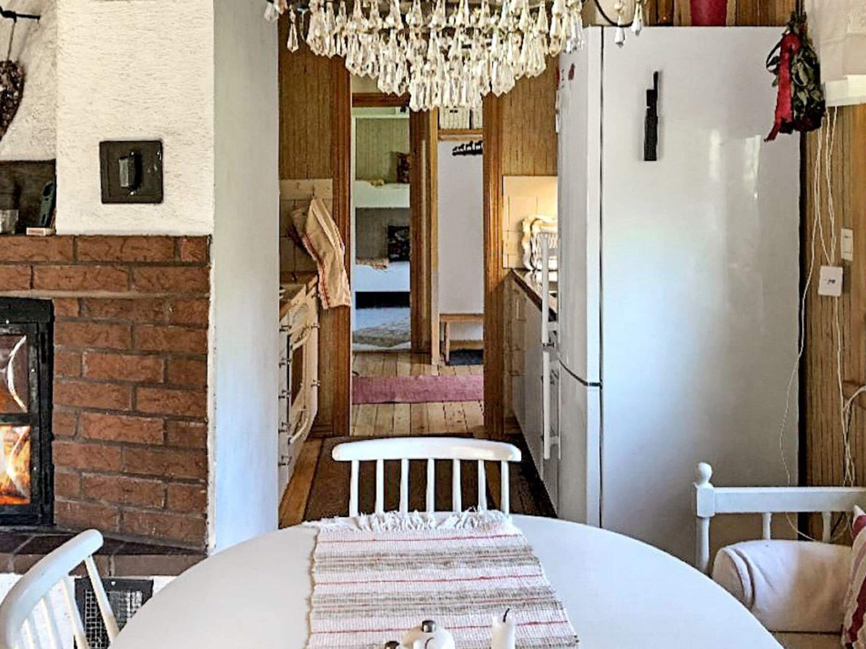 Una cucina accogliente con un frigorifero bianco, un lampadario e una parete in mattoni.