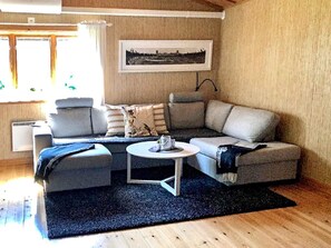 Un soggiorno moderno con un divano componibile, un tavolino rotondo e un quadro incorniciato appeso al muro.