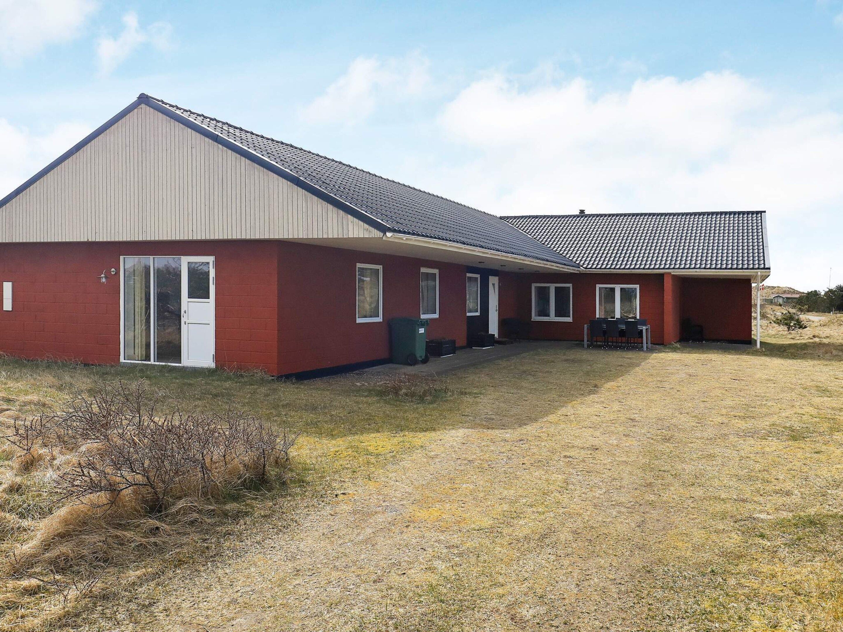 A single-story building with a sloped roof, a front door, and a covered porch area.