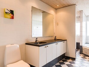 A modern bathroom with a black and white checkered floor, a large mirror, two sinks, and a toilet. - 8 Person Holiday Home on a Holiday Park in Hvide Sande (Hvide Sande)