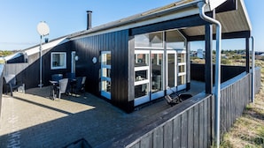 Moderni rakennus, jossa on suuret ikkunat ja katettu ulkoalue.