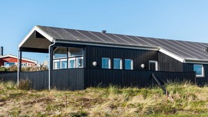 Moderni, yhden kerroksen rakennus, jossa on tumma julkisivu ja kalteva metallikatto.