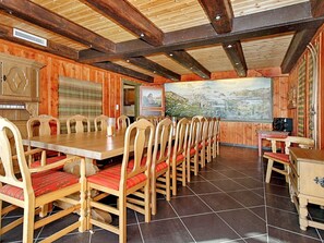 A dining area with wooden tables and chairs, a large painting on the wall, and a wooden cabinet. - 3 Person Holiday Home in BOE Telemark (Midt-Telemark)