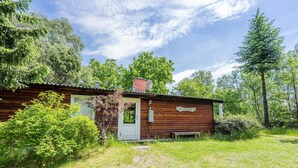 A rustic cabin with a wooden exterior, a white door, and a small porch area. - 4 Person Holiday Home in Norre Nebel (Norre Nebel)