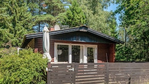 A cabin with a wooden exterior, a sliding glass door, and a fenced yard. - 4 Person Holiday Home in Norre Nebel (Norre Nebel)