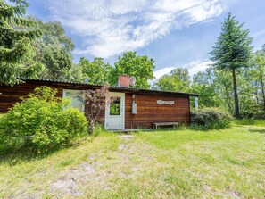 A rustic cabin with a wooden exterior, a chimney, and a door labeled 'DUNELA.' - 4 Person Holiday Home in Norre Nebel (Norre Nebel)