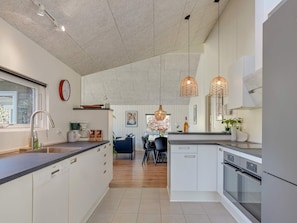 Een moderne keuken met witte kastjes, een vaatwasser en een inbouwoven.