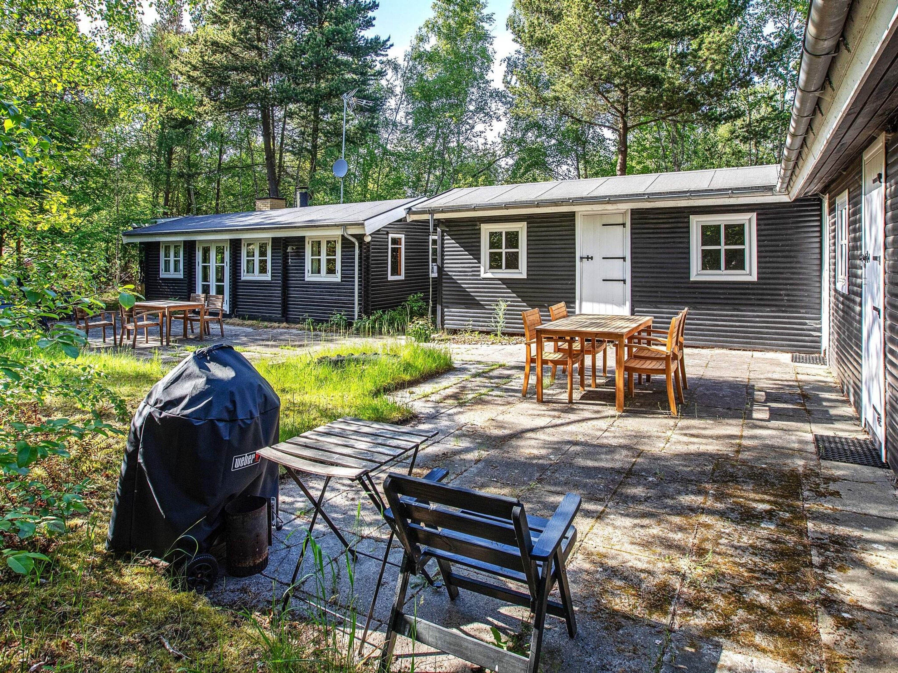 Une cabane dotée d’un patio, de meubles d’extérieur et d’un barbecue.