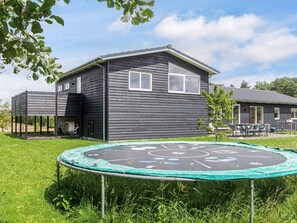 A residential house with a trampoline in the yard.