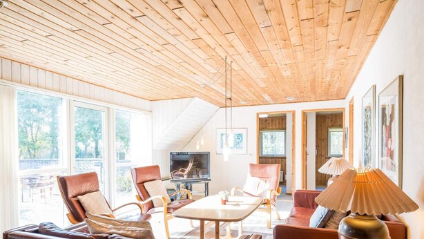Ein modernes Wohnzimmer mit Holzboden, Ledersofas, einem Couchtisch aus Holz und einem Fernseher.