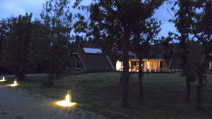 Ein Haus mit gepflasterter Auffahrt und gut beleuchtetem Eingang.