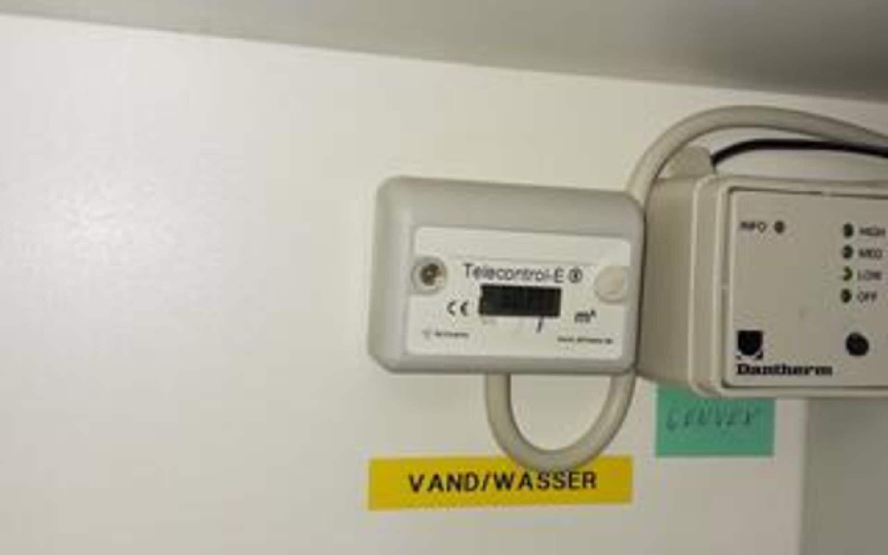 A control panel with a label 'VAND/WASSER' indicating a water valve or faucet.