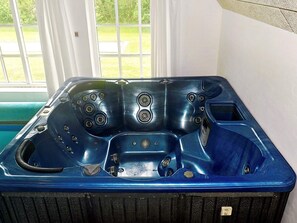 A blue hot tub with multiple jets, a control panel, and a small window. - Holiday Home in Ulfborg (Ulfborg)