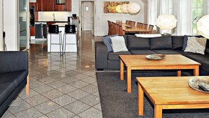 Uma sala de estar moderna com um sofá, mesa de centro e área de jantar.