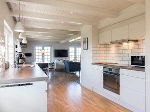 Eine moderne Küche mit weißen Schränken, einer Edelstahl-Dunstabzugshaube und einer Holz Arbeitsplatte.