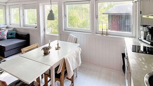 A cozy room with a dining table, a sofa, and a kitchen area with a stove.