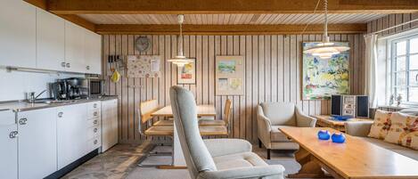 Eine moderne Küche mit Essbereich, Holzboden und einem großen Fenster.