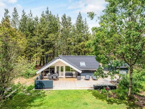A modern house with a deck, surrounded by trees. - 4 Person Holiday Home in Norre Nebel (Norre Nebel)