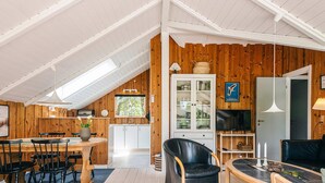 A cozy, open-plan living space with a dining area, kitchen, and seating area. - 4 Person Holiday Home in Norre Nebel (Norre Nebel)