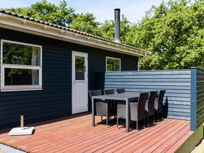 Guests can enjoy a cozy outdoor dining experience on the deck, complete with a table and chairs.