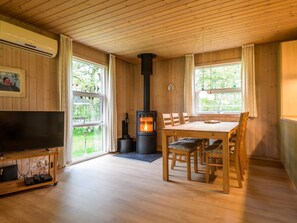 Relax in this inviting room with a high ceiling, large TV, and cozy dining area.