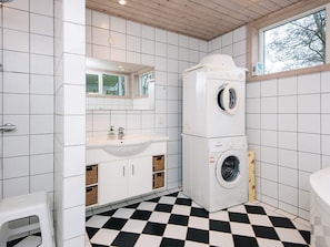 A compact laundry room with a washing machine, a sink, and a mirror. - 5 Star Holiday Home in Fano (Fano)