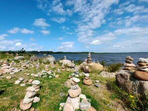 A lakeside view with stacks of rocks and a clear sky. - 4 Person Holiday Home in Henne (Henne)