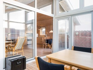 Een modern interieur met een eethoek, keuken en open ruimte met grote ramen.