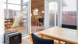 A modern interior with a dining area, kitchen, and large windows. - 4 Person Holiday Home in Henne (Henne)