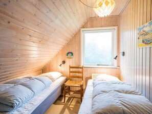A room with two beds, a window, a chair, and a lamp. - 6 Person Holiday Home in Henne (Henne)