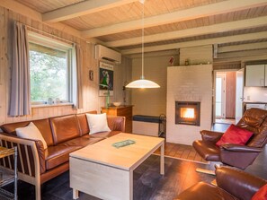 A cozy living room with a leather sofa, a coffee table, and a fireplace. - 6 Person Holiday Home in Henne (Henne)